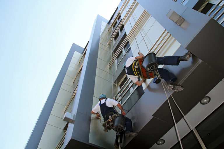 Workers washing the windows facade of a modern office building.